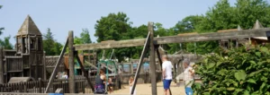 families playing at the outdoor playscape imagination station in downtown brighton on a sunny summer day